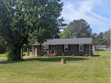 Charming single-story brick home with a well-maintained lawn and mature trees at 1064 Abbott Rd, Henderson, NC 27537