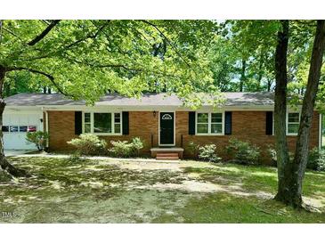 Charming brick ranch home with well-maintained landscaping, black shutters and an arched front door at 1713 S Garnett St, Henderson, NC 27536