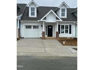 Charming new construction with white siding, a one car garage, and a concrete driveway at 1739 Old Fields Blvd, Haw River, NC 27258