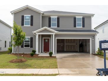 Charming two-story home featuring gray siding, black shutters, a red front door, and an attached two-car garage at 2234 Cherry Creek Rd, Haw River, NC 27258