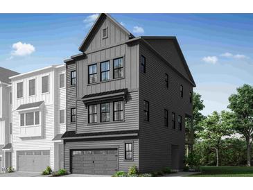 Modern two-story home featuring gray siding, multiple windows, and attached two-car garage at 4611 Mint Leaf Ln, Raleigh, NC 27612
