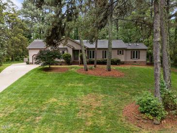 Charming ranch home with lush front lawn and mature trees creating a serene curb appeal at 5109 Knaresborough Rd, Raleigh, NC 27612