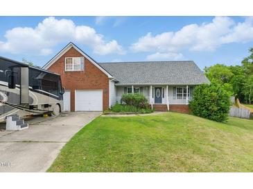 Charming home with a brick and vinyl exterior, attached garage, and a well-maintained lawn at 71 Havistock Ct, Cameron, NC 28326