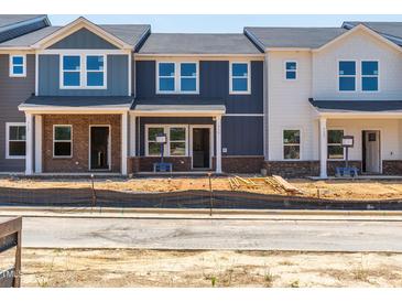 Newly constructed townhomes featuring varied exterior paint colors and brick foundations at 715 Chandler Stone Dr, Zebulon, NC 27597