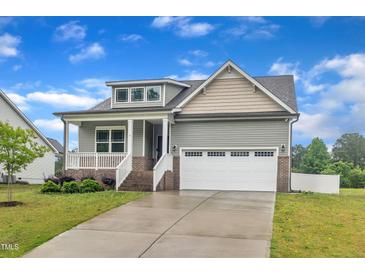 Charming home with an attached two-car garage, a welcoming porch, and a well-manicured front yard at 9 Little Sunshine Brk, Smithfield, NC 27577