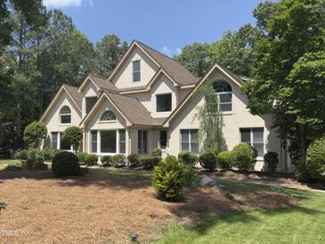 Charming two-story home with mature landscaping, arched windows, and a well-maintained lawn at 90021 Hoey, Chapel Hill, NC 27517