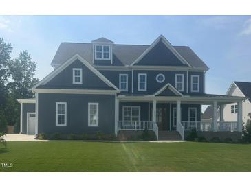 Beautiful two-story home with a manicured lawn, inviting front porch, and classic architectural details at 1017 Azalea Garden Cir, Raleigh, NC 27603
