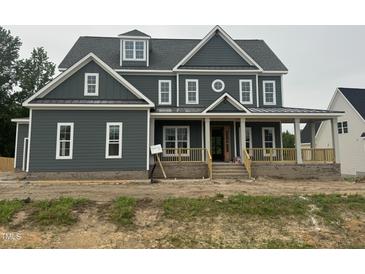 Two-story home featuring a charming facade with a covered front porch and craftsman-style details at 1017 Azalea Garden Cir, Raleigh, NC 27603
