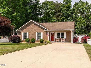 Charming brick home with a well-manicured lawn and inviting front porch at 1290 Pyrtle Dr, Graham, NC 27253