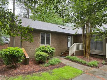 Charming brick home featuring a landscaped front yard and a welcoming entryway with a white railed porch at 200 W Woodcroft Pkwy # 52A, Durham, NC 27713