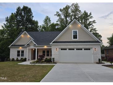 Charming home with a white brick exterior, manicured lawn and a two car garage at 2112 Coy St, Burlington, NC 27215