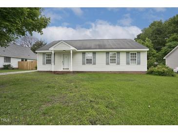 Charming single-story home features a well-manicured lawn and classic architectural details under a bright sky at 308 Sandy Knob Ln, Rocky Mount, NC 27803