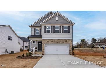 Charming two-story home with gray siding, stone accents, and a two-car garage at 428 Longleaf Glen Lane, Zebulon, NC 27597