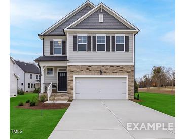 Charming two-story home with a stone-accented facade, a two-car garage, and a well-manicured front lawn at 428 Longleaf Glen Lane, Zebulon, NC 27597