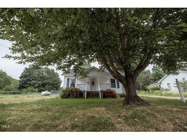 Charming home with lush green lawn and large shade tree at 6 1St St, Franklinton, NC 27525