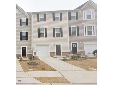 Charming townhomes featuring individual garages and matching front doors and trim details at 904 Romeria Dr, Durham, NC 27713