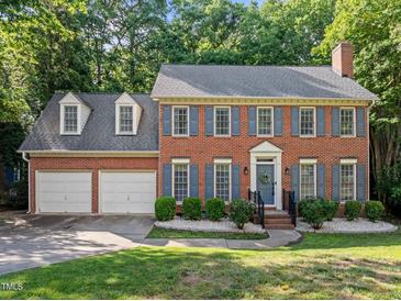 Charming brick home featuring blue shutters, a well-manicured lawn, and a two-car garage at 1013 New Chester Ct, Apex, NC 27502
