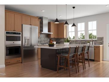 Well-lit kitchen with stainless steel appliances, wood cabinets, island with seating and modern pendant lighting at 1038 Zelkova Ln, Chapel Hill, NC 27517