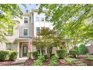 Charming townhouse featuring brick and siding, complemented by a well-manicured lawn and mature trees at 1427 Van Page Blvd, Raleigh, NC 27607