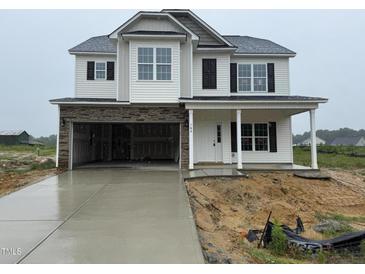Two-story home with stone accents, a two-car garage, and a welcoming front porch at 162 Tuskeegee Dr, Smithfield, NC 27577