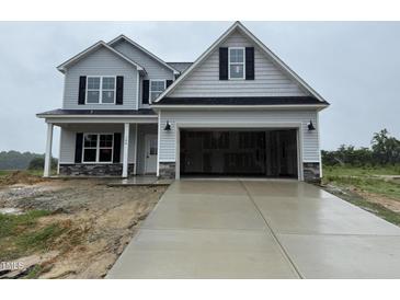 New two-story home featuring an attached two-car garage, gray siding, and a covered front porch at 188 Tuskeegee Dr, Smithfield, NC 27577