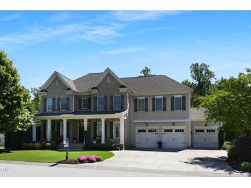 Charming two-story home featuring a three-car garage and a welcoming front porch at 1927 Napoli Dr, Apex, NC 27502
