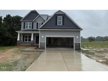 Two-story home featuring an attached two car garage, gray siding and black shutters at 202 Tuskeegee Dr, Smithfield, NC 27577