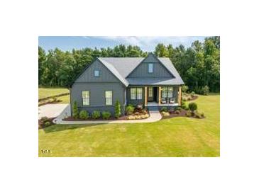 Beautiful two-story home with a manicured lawn and inviting front porch at 223 Lindo Johnson Rd, Pittsboro, NC 27312