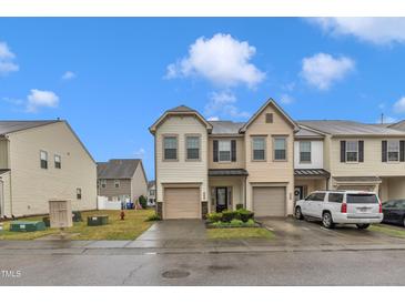 Charming townhome with two-car garage, landscaped front yard, and neutral exterior at 303 Leighann Ridge Ln, Rolesville, NC 27571