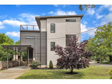 Modern two-story home featuring light siding, dark accents, a carport, and a rooftop patio at 304 S Tarboro St, Raleigh, NC 27610