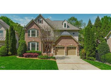 Traditional brick home featuring a two-car garage and well-manicured front lawn at 3911 Morvan Way, Raleigh, NC 27612