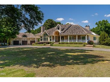 Sprawling home with a circular driveway, stone accents and a covered front porch at 4038 Carpenter Pond Rd, Durham, NC 27703