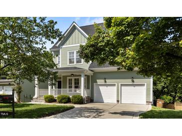 Charming two-story home featuring a welcoming front porch and a two-car garage at 436 Edgepine Dr, Holly Springs, NC 27540