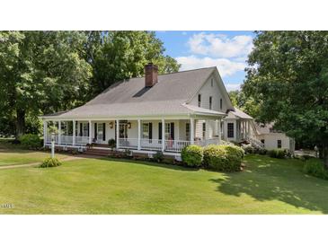 Charming home with a large, inviting porch and manicured lawn, perfect for relaxing and enjoying the outdoors at 5308 Stableview Ct, Holly Springs, NC 27540