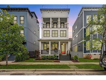 Charming three-story home with a welcoming front porch and manicured lawn at 610 Velma Hopkins Ln, Raleigh, NC 27603