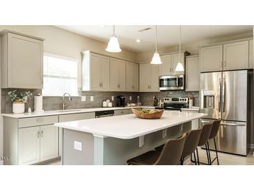 Bright kitchen features stainless steel appliances, large island with seating, and neutral color palette at 75 E American Marigold Dr # 37, Benson, NC 27504