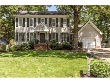 Charming two-story home with a well-manicured lawn, black shutters, and attached two-car garage at 7517 Chippenham Ct, Raleigh, NC 27613