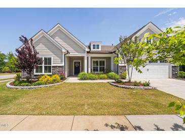 Charming home featuring manicured lawn, stone accents, and inviting front porch at 901 Del Webb Manor Ave, Wake Forest, NC 27587