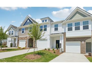 Charming townhomes featuring a mix of siding and stone accents, complemented by well-manicured lawns and private garages at 904 Kensley Grove Ln # 70, Fuquay Varina, NC 27526