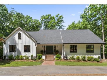 Charming single-story home with a brick walkway and a well-manicured lawn and surrounded by mature trees at 10817 Brass Kettle Rd, Raleigh, NC 27614