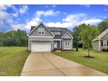 Charming gray two-story home featuring a well-manicured lawn and attached two-car garage at 1109 Agio Ct, Zebulon, NC 27597