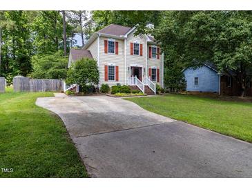Charming two-story home with cream siding, red shutters, a white railed porch, and a curved concrete driveway at 1605 Hall Blvd, Garner, NC 27529