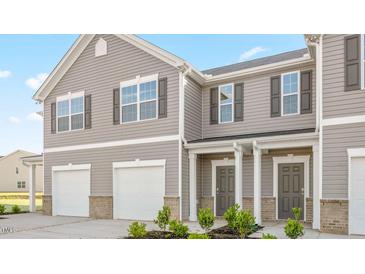 Charming townhome showcasing gray siding, white trim, and an attached garage at 239 Moyer Dr, Graham, NC 27253