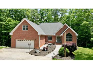 Charming brick home featuring an attached two-car garage and beautifully landscaped front yard at 3750 Mebane Rogers Rd, Mebane, NC 27302