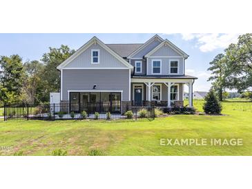 Charming two-story home with gray siding, inviting porch, and well-maintained lawn and black aluminum fence at 456 Golden Dragonfly St, Wake Forest, NC 27587