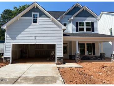 Charming two-story home featuring a spacious two-car garage, stone accents, and a covered front porch at 456 Golden Dragonfly St, Wake Forest, NC 27587