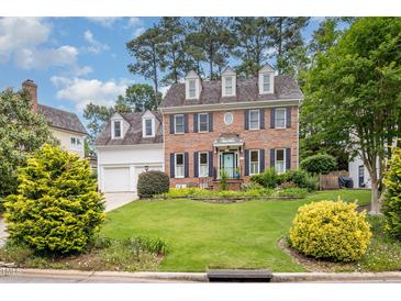 Charming two-story brick home with a well-manicured lawn and mature trees at 8420 Caldbeck Dr, Raleigh, NC 27615