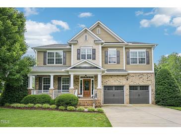 Inviting two-story home featuring a brick facade, manicured lawn, and attached two-car garage at 1008 Wolfs Bane Dr, Apex, NC 27539