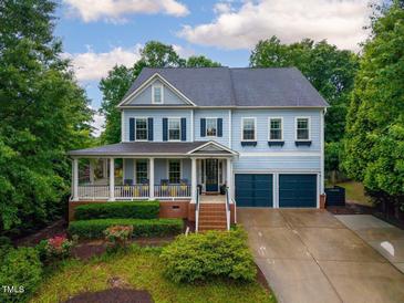 Charming two-story home with a well-manicured lawn, inviting front porch, and attached two-car garage at 101 Ironcreek Pl, Apex, NC 27539