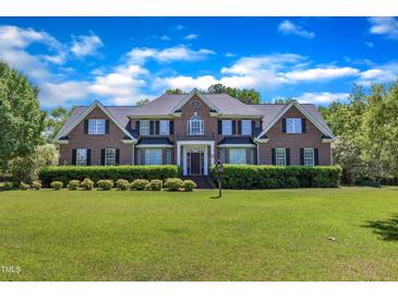 Beautiful brick home with a manicured lawn and lush landscaping at 107 Stargrass Ave, Clayton, NC 27527
